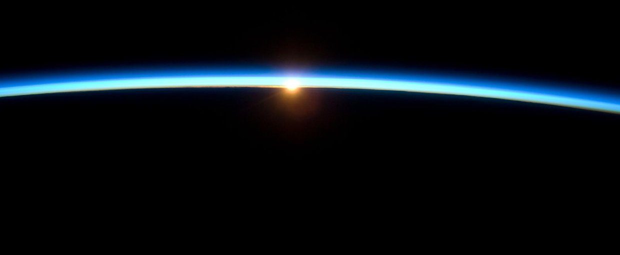 The thin line of Earth's atmosphere and the setting sun are featured in this image photographed by the crew of the International Space Station while space shuttle Atlantis on the STS-129 mission was docked with the station.