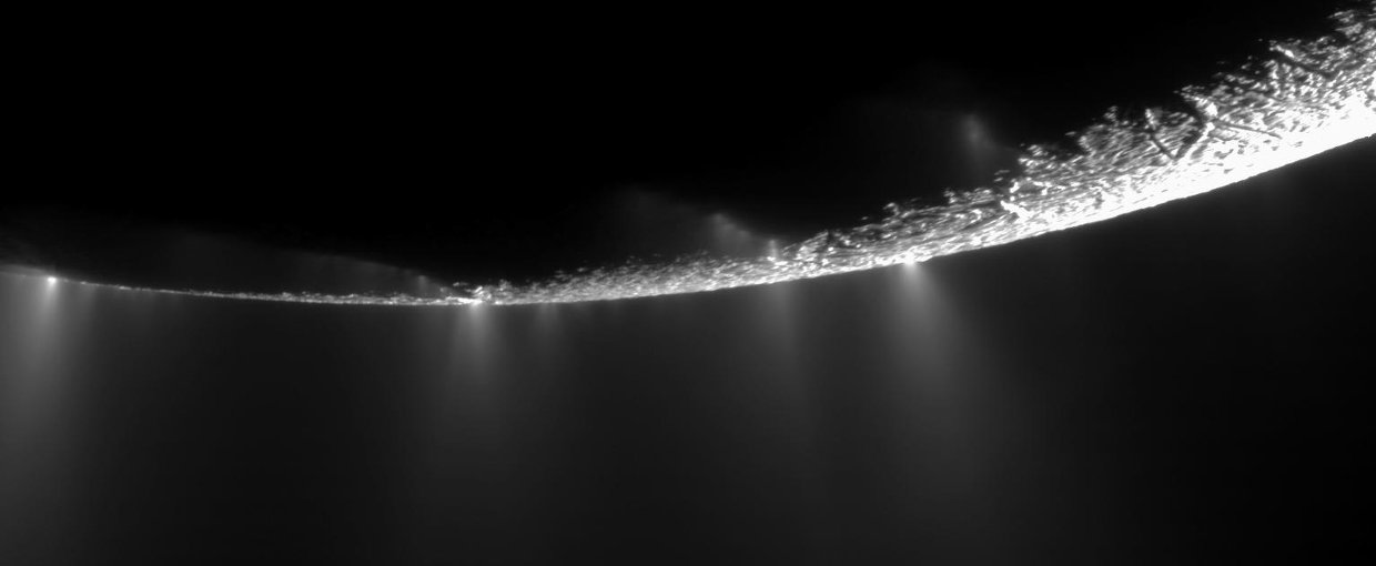 Plumes erupting off the surface of Enceladus, an icy moon.