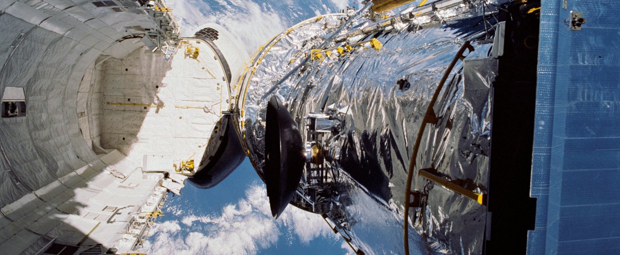 In this April 25, 1990, photograph taken by the crew of the STS-31 space shuttle mission, the Hubble Space Telescope is suspended above shuttle Discovery's cargo bay some 332 nautical miles above Earth. Credit: NASA