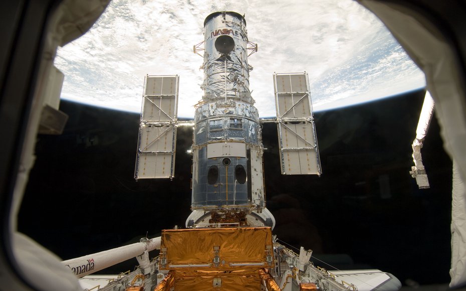 The Hubble Space Telescope stands tall in the cargo bay of the Space Shuttle Atlantis following its capture and lock-down in Earth orbit. Credit: NASA
