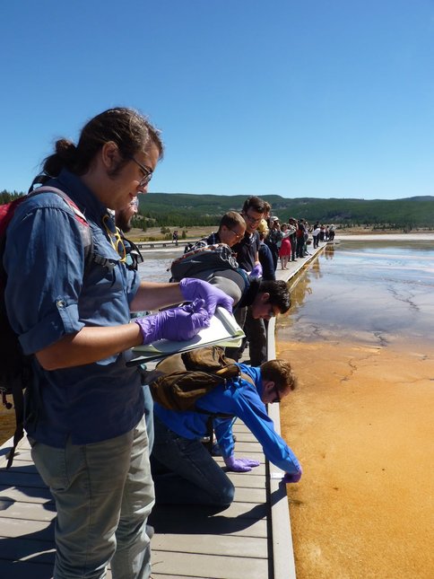Figure 2.  University of Washington Astrobiology graduate students performing reflectance spectra measurements at Grand Prismatic Hot Springs in Yellowstone National Park.