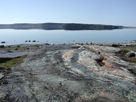 A photograph of an outcrop of metamorphosed volcanosedimentary rocks from the Porpoise Cove locality, Nuvvuagittuq supracrustal belt, Canada. Some of these rocks have Sm/Nd ages in excess of 4.0 Ga and may be the oldest rocks on Earth.