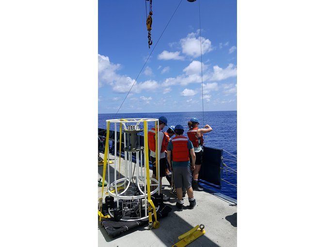Jaclyn Saunders (far right) fixes the line on a McLane instrument that pumps large volumes of seawater in order to extract the DNA. The left instrument measures properties such as temperature, salinity and depth and collects smaller samples of seawater.