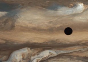 Sixteen frames from Voyager 1's flyby of Jupiter in 1979 were merged to create this image. The shadow of Jupiter's moon Io can be seen near the center of the image.