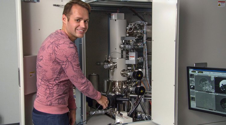 Pierre Haenecour, the study's lead author, is pictured with one of the ultra-high-resolution electron microscopes used to obtain chemical and microstructural information about the stardust grain.
