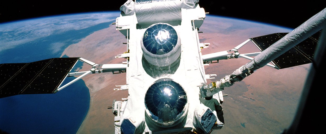 The Compton Gamma-Ray Observatory prior to deployment, still attached to space shuttle Atlantis by the robot arm, during the STS-37 mission in April 1991.