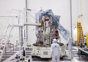 The main body of NASA's Europa Clipper being unwrapped in a main clean room at the NASA Jet Propulsion Laboratory, as engineers and technicians inspect it just after delivery in early June 2022.