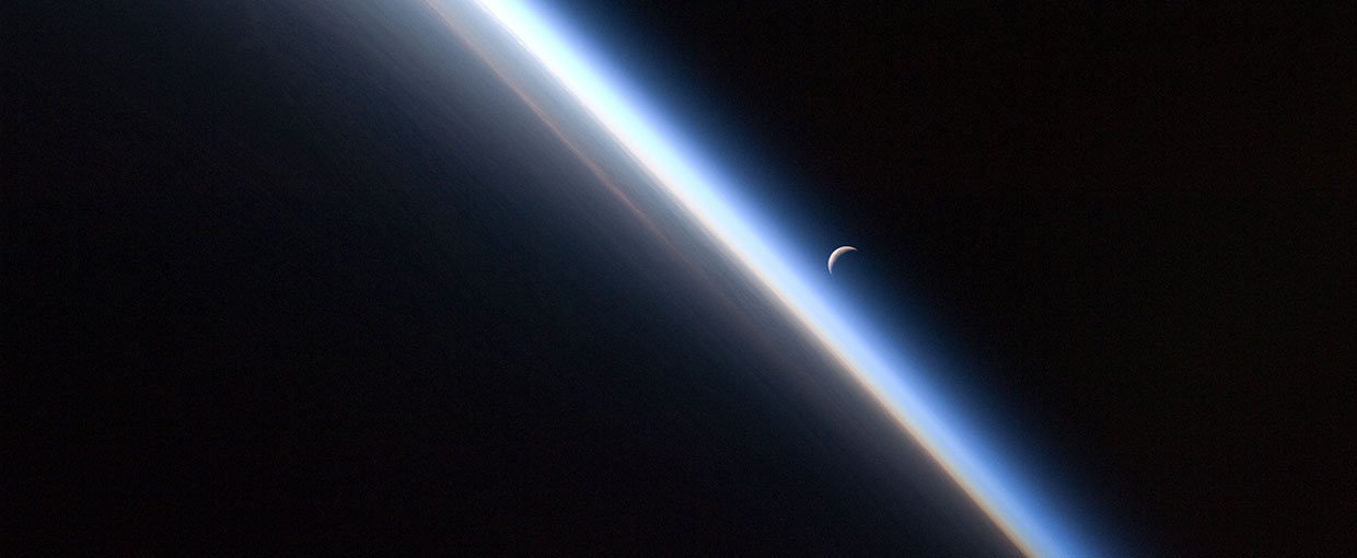 A setting last quarter crescent moon and the thin line of Earth's atmosphere are photographed by an Expedition 24 crew member as the International Space Station passes over central Asia.