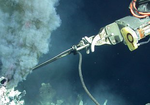 The remotely operated vehicle (ROV) Jason II is shown using a temperature probe to measure the temperature of hydrothermal vent water from a hydrothermal vent along along the East Pacific Rise.