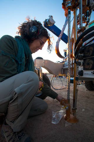 NASA systems engineer Arwen Davé inspecting the drill attached to the ARADS rover on a previous deployment to Chile's Atacama Desert in February 2018.