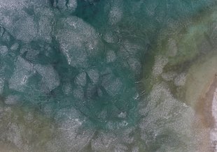 An icy lake in Svalbard, Norway, taken by an unmanned aerial vehicle. Life on Earth may have begun in an environment with both water and ice, and modern analogs may help the scientific community understand how.
