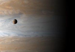 The moon Io orbits Jupiter in this image from NASA's Cassini spacecraft. Jupiter and Io appear deceptively close in this image, when in fact the moon is orbiting 217,000 miles from the gas giant planet.