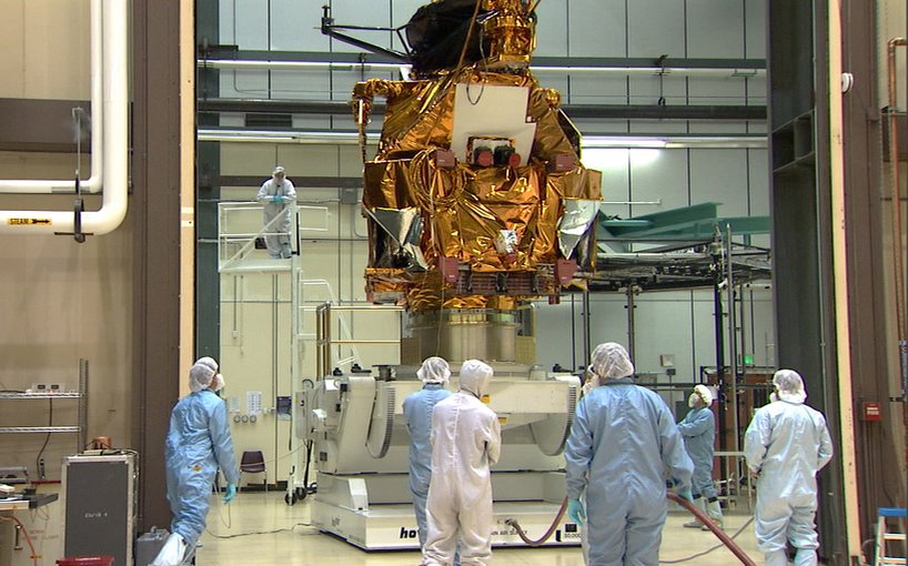 A group of engineers and technicians watch as the Mars Reconnaissance Orbiter is lifted in a cleanroom at Lockheed Martin in Littleton, Colorado during the orbiter's assembly, test and launch operations phase.