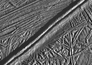 A double ridge cutting across the surface of Europa is seen in this mosaic of two images taken by NASA’s Galileo during the spacecraft’s close flyby on Feb. 20, 1997.