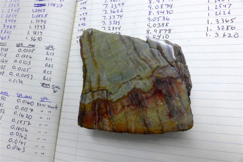 This sample of 3.26-billion-year-old barite shows the granular barite (gray-green areas) that was influenced by ocean water, and bladed barite (vertical black bands) that was by ocean water and water circulating below the sea floor. David Tenenbaum
