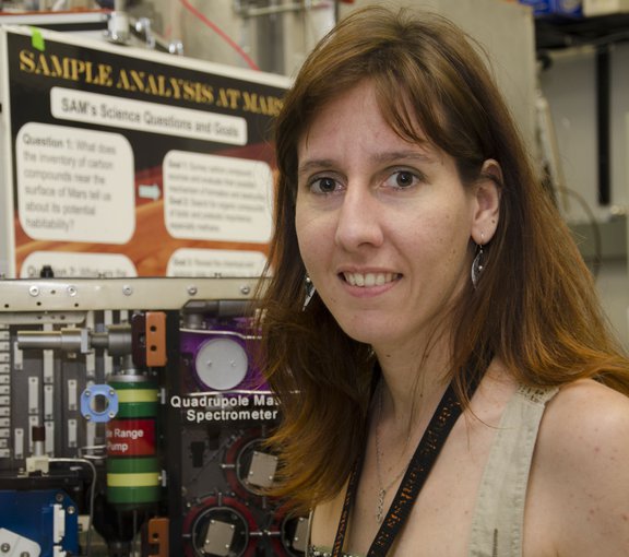 Caroline Freissinet of NASA's Goddard Space Flight Center in from of a model of the SAM instrument suite.