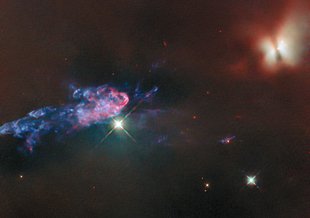 A point of light is left of center against a dark background. To the left of the point is a blue/purple cloud-like structure that spreads longitudinally toward the left of frame. Upper right is an orangish, almost butterfly-like structure of light.