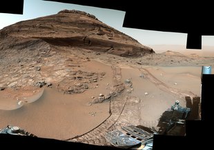 Image from the Curiosity rover showing Bolivar hill. It appears to the left of the image as a rounded mounded of stacked layers of rock.