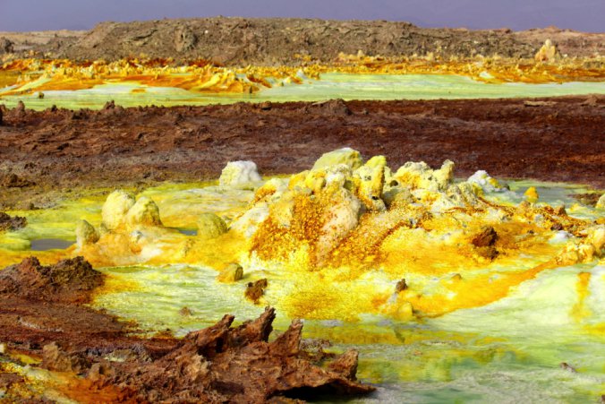 Hydrothermal system at Ethiopia’s Danakil Depression, where uniquely extreme life persists in salt chimneys and surrounding water. Yellow deposits are a variety of sulphates and red areas are deposits of iron oxides. Copper salts color the water green.
