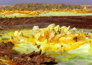 Hydrothermal system at Ethiopia’s Danakil Depression, where uniquely extreme life persists in salt chimneys and surrounding water. Yellow deposits are a variety of sulphates and red areas are deposits of iron oxides. Copper salts color the water green.