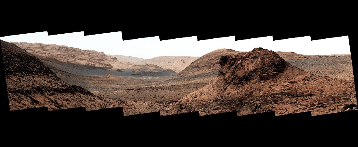 Panoramic view of the rust-colored martian surface from Curiosity. The sky is a hazy pink.