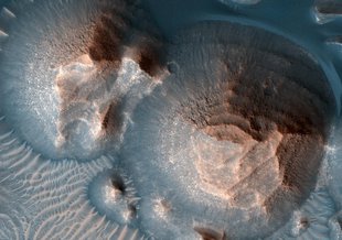 This image from NASA's Mars Reconnaissance Orbiter shows several craters in Arabia Terra that are filled with layered rock, often exposed in rounded mounds. The bright layers are roughly the same thickness, giving a stair-step appearance.