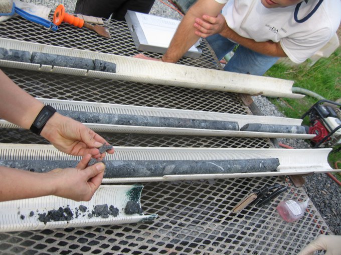 Drill cores recovered from the Chesapeake Bay Impact Structure (CBIS). In this image, cores are being examined for geological studies after biological samples have been collected.