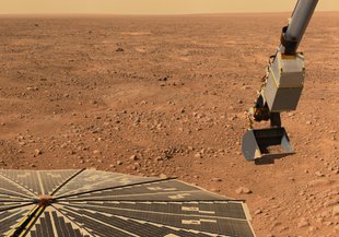 This image shows NASA’s Phoenix Mars Lander’s solar panel and the lander’s Robotic Arm with a sample in the scoop, looking west during Phoenix’s Sol 16 (June 10, 2008), or the 16th Martian day after landing.