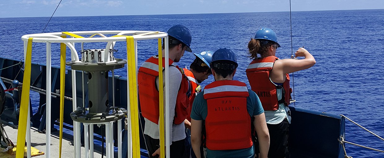Jaclyn Saunders (far right) fixes the line on a McLane instrument that pumps large volumes of seawater in order to extract the DNA. The left instrument measures properties such as temperature, salinity and depth and collects smaller samples of seawater.
