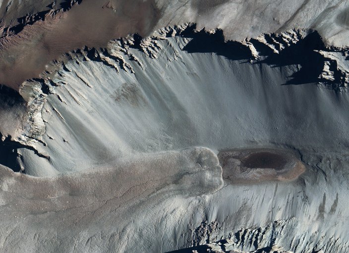 A satellite image of Don Juan Pond, showing dark streaks on the surrounding hillsides reminiscent of Recurring Slope Lineae seen on Mars.