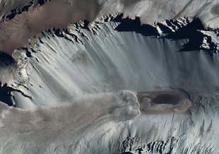 A satellite image of Don Juan Pond, showing dark streaks on the surrounding hillsides reminiscent of Recurring Slope Lineae seen on Mars.