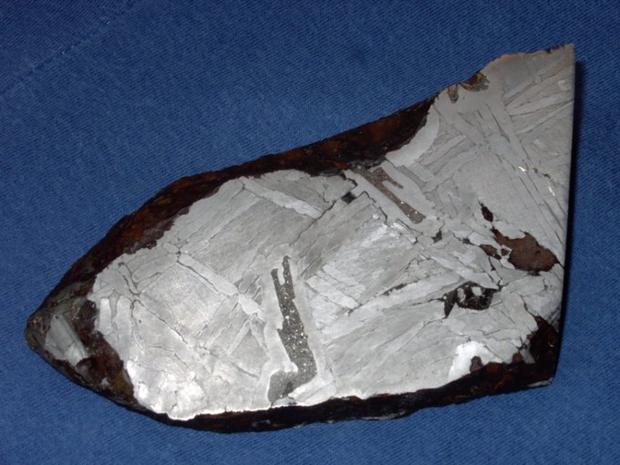 This 15cm wide fragment of the Seymchan meteorite found in Russia in 1967 is an iron-nickel pallasite. The long filament of dark grey material in the center is schreibersite.