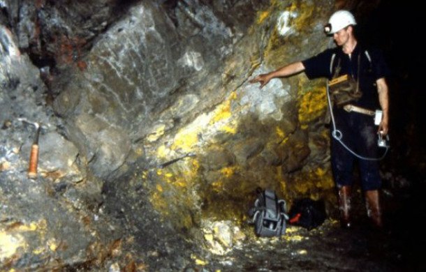 A “fossil” natural nuclear reactor site in the Okio region of Gabon. The large uranium deposit present underwent nuclear fission on and off for hundreds of thousands of years some 2 billion years ago. The yellow rock is uranium oxide.