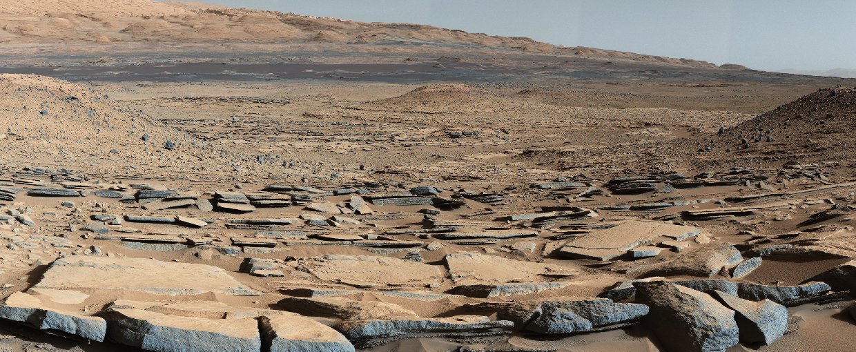 A view from the "Kimberley" formation on Mars taken by NASA's Curiosity rover. The strata in the foreground dip towards the base of Mount Sharp, indicating the ancient depression that existed before the larger bulk of the mountain formed.