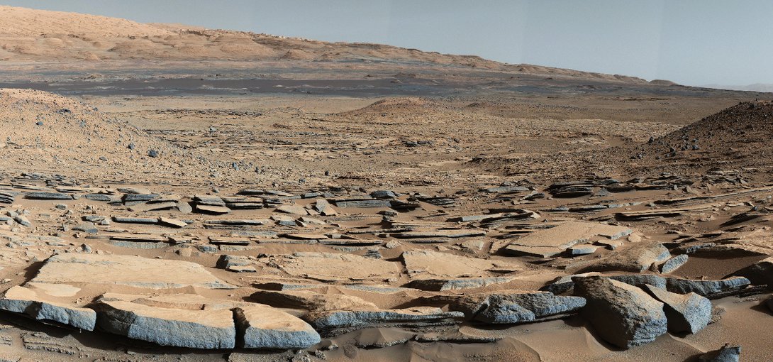 A view from the "Kimberley" formation on Mars taken by NASA's Curiosity rover. The strata in the foreground dip towards the base of Mount Sharp, indicating the ancient depression that existed before the larger bulk of the mountain formed.