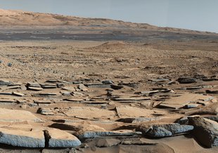 A view from the "Kimberley" formation on Mars taken by NASA's Curiosity rover. The strata in the foreground dip towards the base of Mount Sharp, indicating the ancient depression that existed before the larger bulk of the mountain formed.