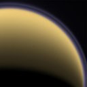 Encircled in purple stratospheric haze, Titan appears as a softly glowing sphere in this colorized image taken one day after Cassini's first flyby of the moon on July 2, 2004.