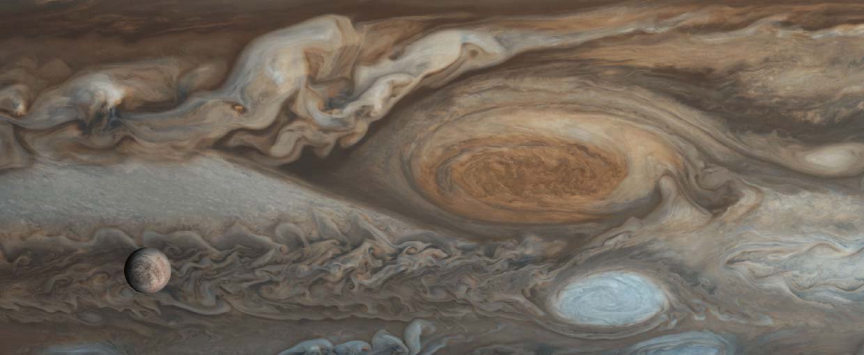 Sixteen frames from Voyager 1's flyby of Jupiter in 1979 were merged to create this image. Jupiter's Great Red Spot is visible in the center. Jupiter's moon Europa can be seen in the foreground at the bottom left of the image.