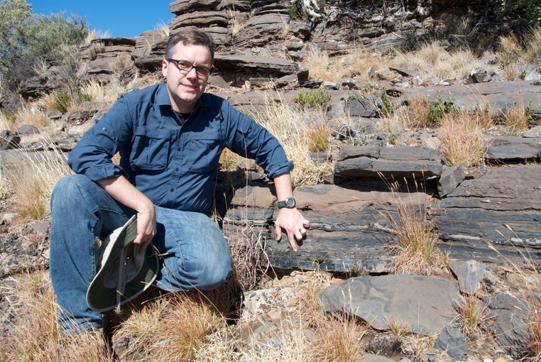 Andrew Czaja indicates the layer of rock from which fossil bacteria were collected on a 2014 field excursion near the town of Kuruman in the Northern Cape Province of South Africa. Source: Aaron Satkoski