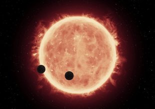 This illustration shows two Earth-sized worlds passing in front of their parent red dwarf star, which is much smaller and cooler than our sun.