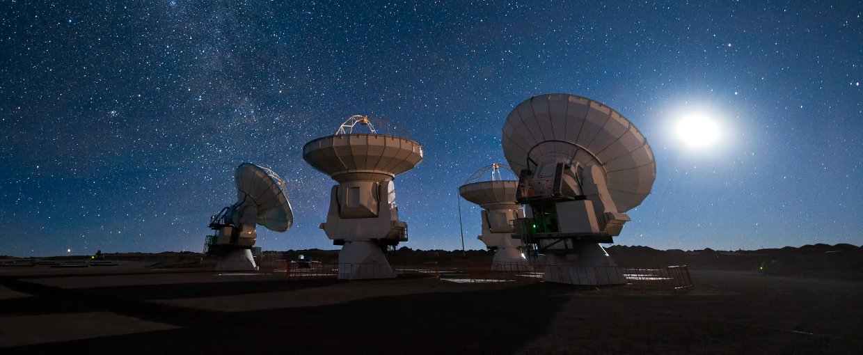 Four antennas of the Atacama Large Millimeter/submillimeter Array (ALMA) gaze up at the star-filled night sky.