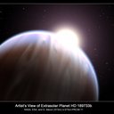 This illustration depicts the extrasolar planet HD 189733b with its parent star peeking above its top edge. 