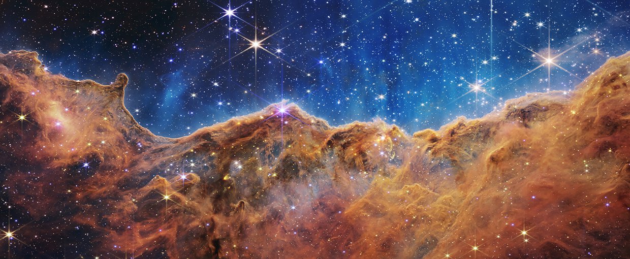 The edge of a nearby, young, star-forming region called NGC 3324 in the Carina Nebula as captured in infrared light by NASA’s Webb Space Telescope. This image reveals for the first time previously invisible areas of star birth.