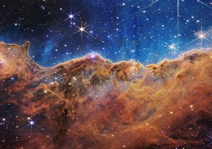 This image shows the edge of a nearby, young, star-forming region called NGC 3324 in the Carina Nebula. Captured in infrared light by NASA’s new James Webb Space Telescope, this image reveals for the first time previously invisible areas of star birth.
