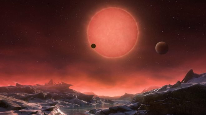 This artist’s impression shows an imagined view from the surface one of the three planets orbiting an ultracool dwarf star just 40 light-years from Earth that were discovered using the TRAPPIST telescope at ESO’s La Silla Observatory.