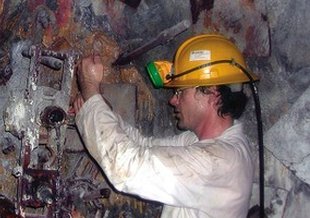 Tullis Onstott of Princeton University opens a borehole in a section of rock wall in a South African mine.
