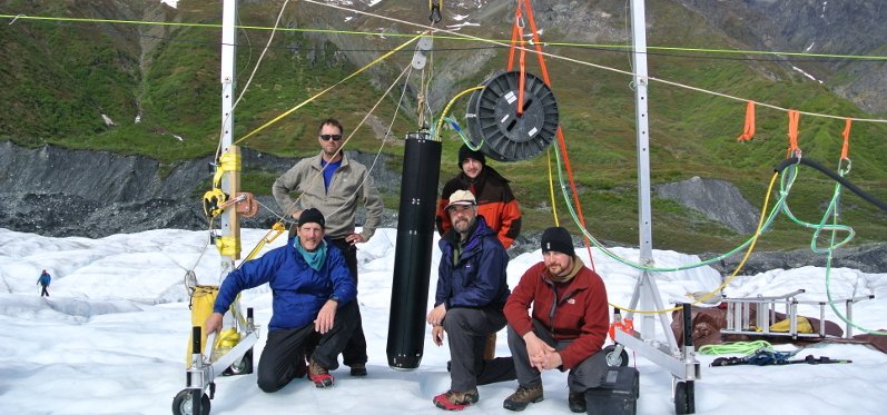 The Stone Aerospace team with VALKYRIE (the black tube hanging on the apparatus in the middle of the picture) on the Matanuska glacier during testing in 2014. Image: Stone Aerospace
