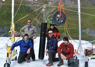 The Stone Aerospace team with VALKYRIE (the black tube hanging on the apparatus in the middle of the picture) on the Matanuska glacier during testing in 2014. Image: Stone Aerospace