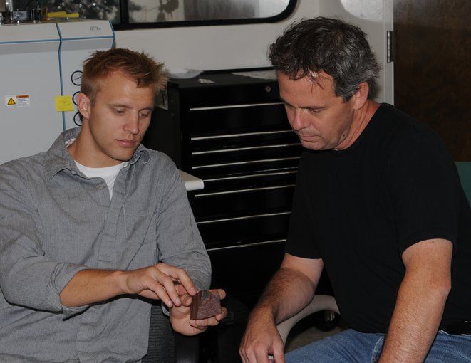 Noah Planavsky (left) and Timothy Lyons are seen here examining a rock sample in the lab. Photo credit: UCR Strategic Communications.
