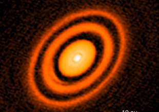 The addition of false color to an image captured by the Atacama Large Millimeter/submillimeter Array, or ALMA, reveals a series of rings around a young star named HD163296.